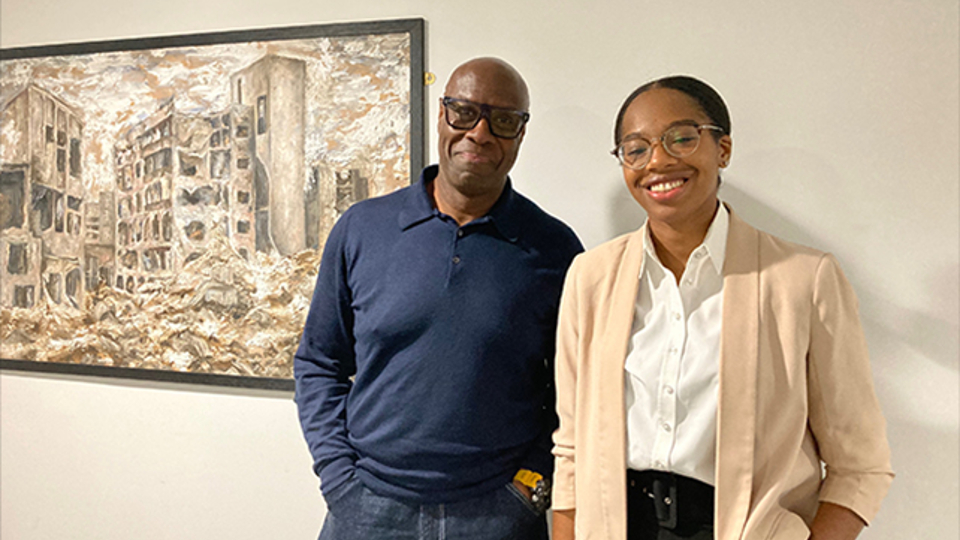 Mike Wedderburn and Renae Huggan-Broughton stand together infront of the oil painting 'Ayria' by alumna Sara Osman.